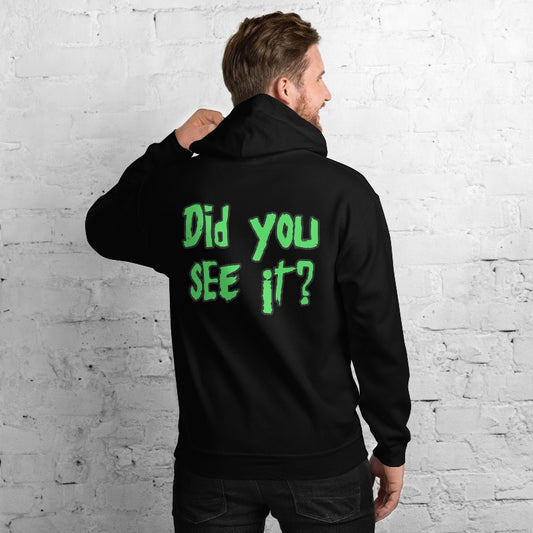 A person stands against a white brick wall, wearing a two-sided black hoodie with the text "Did you SEE it?" in green on the back, reminiscent of Nuke's Top 5.