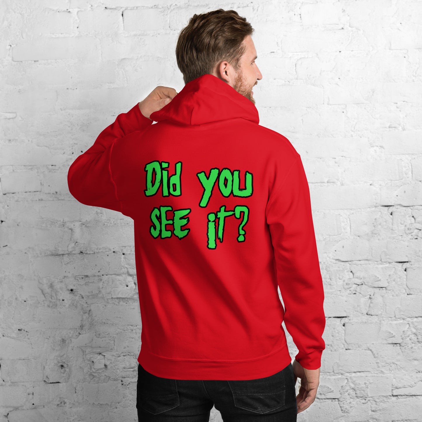 A person stands against a white brick wall, wearing a two-sided black hoodie with the text "Did you SEE it?" in green on the back, reminiscent of Nuke's Top 5.